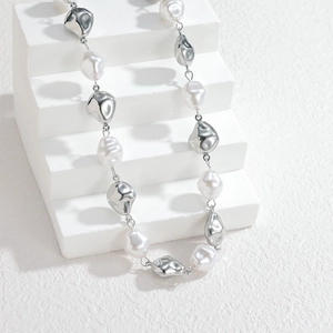 Collier minimaliste avec perles irrégulières et billes argentées sur escalier blanc