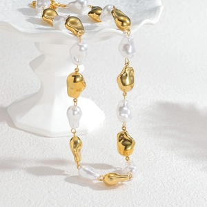 Modern Baroque pearl and irregular golden metal bead necklace on elegant white base