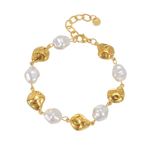 Gold irregular lava metal and baroque pearl bracelet with lobster clasp on white background