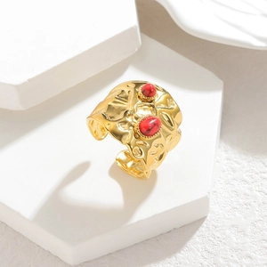 Hammered gold wide band open ring with red stone inlays on minimalist stone background