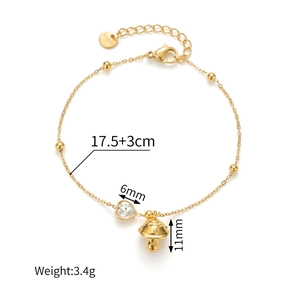 Detail of gold stainless steel bracelet with crystal heart and mushroom charms