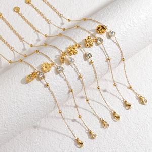 Detail of 18k gold layered bracelets with flower pendants and sparkling zircons