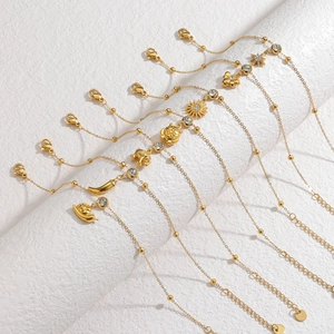Detailed view of 18k gold layered bracelets featuring multi-element charms and S925 stamp