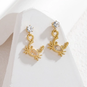 Boucles d'oreilles crabe en or 18 carats avec zircons sur présentoir en pierre épuré