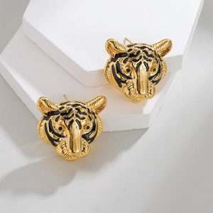 Detailed 18k gold plated tiger head stud earrings with green eyes on white display pedestal