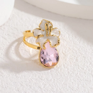 Eleganter 18k vergoldeter Blumenring mit rosa Tropfenkristall auf weißem Hintergrund