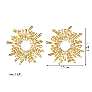 Detailed view of gold sunburst earrings with size labels and sparkling crystal inlay