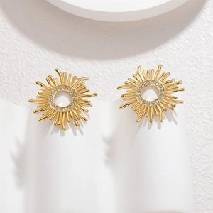 Gold sunflower stud earrings with sparkling zircons displayed on a wavy stand