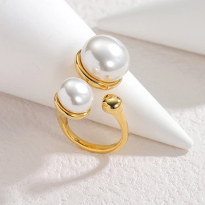 Elegant 18k gold plated open ring featuring two white pearls on a textured background