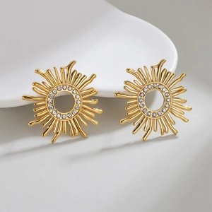 18k gold plated sunflower stud earrings with crystals on a minimalist white ceramic tray