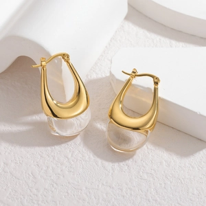 Boucles d'oreilles dorées géométriques en U avec des pendentifs sphériques clairs