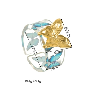 Detailed view of clear acrylic ring with gold butterfly ornament and size dimensions