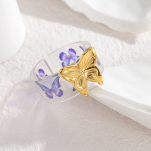 French style open ring featuring a gold metal butterfly on a transparent acrylic band