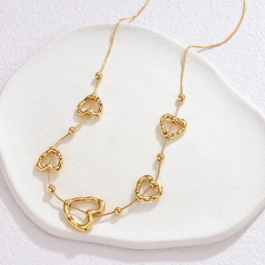 Collier minimaliste en or 18k avec pendentifs cœurs évidés et perles sur chaîne serpent