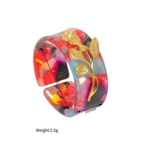 Vue détaillée d'une bague ouverte en acétate coloré avec ornement de rose dorée