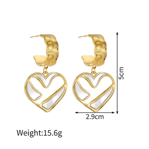 Détail de boucles d'oreilles cœur 18k de 5cm avec émail blanc et texture tissée