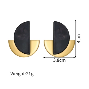 Vue détaillée de boucles d'oreilles dorées 18k avec marbre noir et dimensions de 4 cm