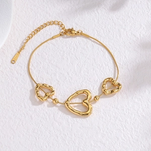 Gold stainless steel snake chain bracelet featuring hollow heart charms and bead accents