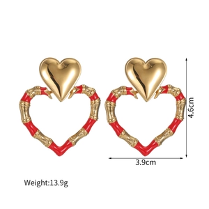 Detail of 18k gold heart earrings with red enamel bamboo texture and size markings
