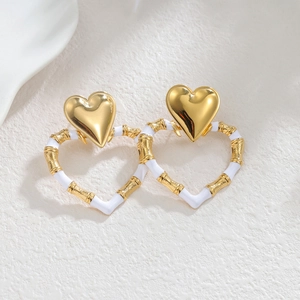 Chic 18k gold heart earrings with white enamel bamboo texture design on white surface