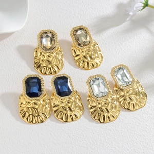 Macro detail of 18k gold plated geometric earrings with large cubic zirconia stones