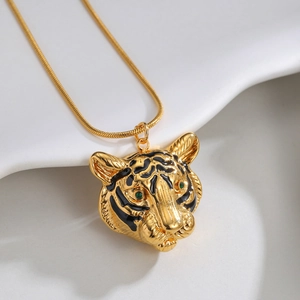 Collier tête de tigre dorée avec yeux verts et émail noir sur une chaîne serpent chic