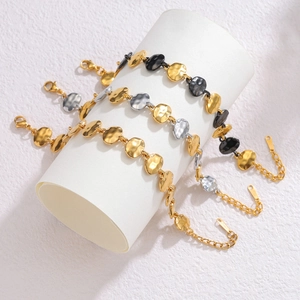 Detail of hammered oval link bracelets in gold, silver and black metal with lobster clasp