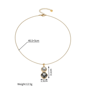 Detail of 18k gold bead chain necklace with dual geometric crystal pendants and S.Steel tag