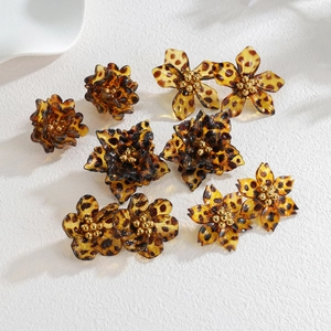 Macro detail of leopard print resin flower earrings with elegant golden center beads