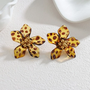 Acrylic leopard print flower earrings with golden core on a white marble tray