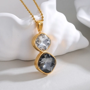 Minimalist gold necklace with geometric white and smoky grey zircon pendants on a bead chain
