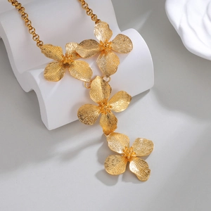 Exquisite 18k gold floral pendant necklace with brushed texture on white wavy stand