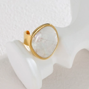 Minimalist 18k gold irregular mother of pearl open ring on a white artistic pedestal