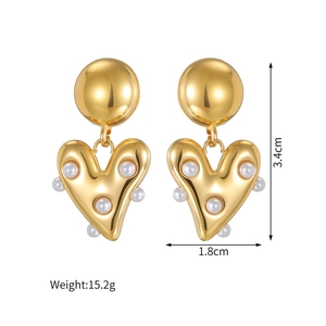 Gros plan sur les boucles d'oreilles cœur en or 18k avec perles et détails de taille
