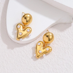 Boucles d'oreilles cœur en or 18k avec perles sur un support blanc moderne