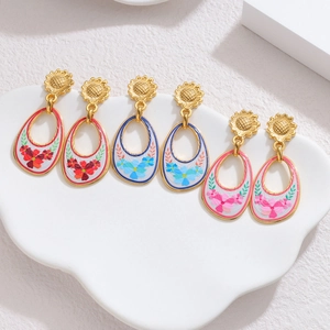 Detail of vintage floral earrings set with golden sunflowers and painted oval charms