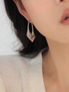 Close-up of elegant silver teardrop earrings on model with polished metal finish