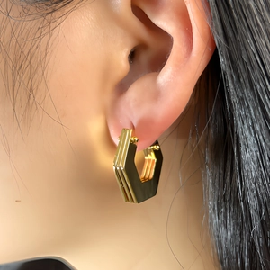 Chic multi-layer gold geometric hexagonal earrings shown on model with polished finish