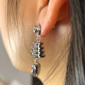 Macro shot of silver tiered heart earrings with high-polish metallic finish details