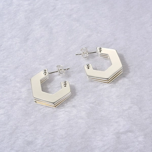 Detail view of silver geometric hexagonal multi-layer earrings with butterfly backs