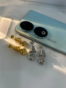 Detail of pagoda heart earrings in gold and silver finish with metallic gloss