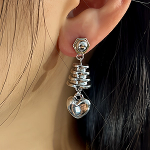 Close-up of a silver heart pagoda drop earring with a modern stacked spiral design