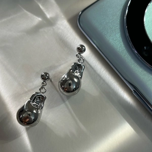 Macro detail of silver lava drop earrings with polished irregular metal texture