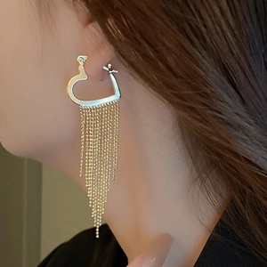 Luxurious gold heart hoop earrings with long bead tassels on a female model
