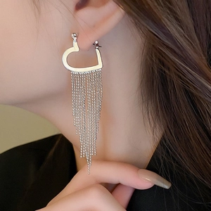 Elegant long silver tassel earrings with hollow heart shape on a female model