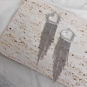 Elegant long silver heart hoop earrings with sparkling tassel chains on stone base