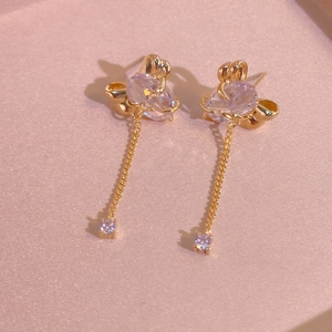 Boucles d'oreilles nœud plaquées or 24K avec pierres lavande sur fond en soie rose