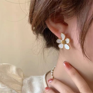 Elegant 925 silver flower stud earrings with white petals and gold trim worn by model