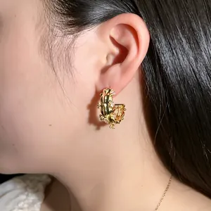 Exquisite gold squirrel earrings with sparkling zircons worn by a female model