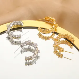 Elegant gold and silver hoop earrings with textured finish and cubic zirconia accents